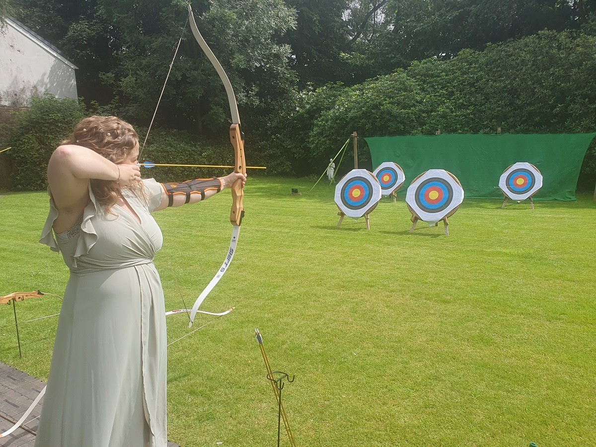 Fun activity for a wedding guest - bridesmaid enjoying archery at The Higher Trapp House Hotel